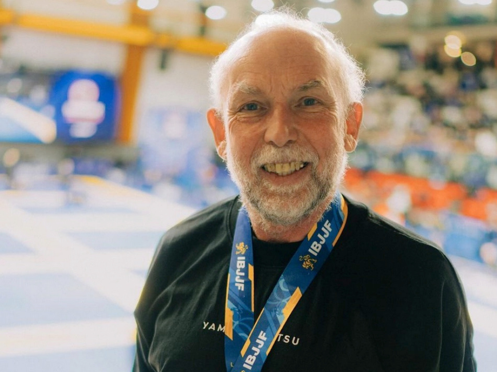 Richard smiles while wearing a gold medal